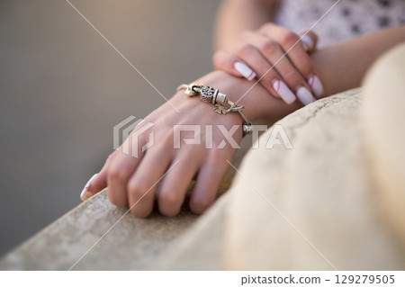 close-up of a girl's hand with a beautiful manicure and a jewelry bracelet on her hand close-up of a girl's hand with a beautiful manicure and a jewelry bracelet on her hand 129279505