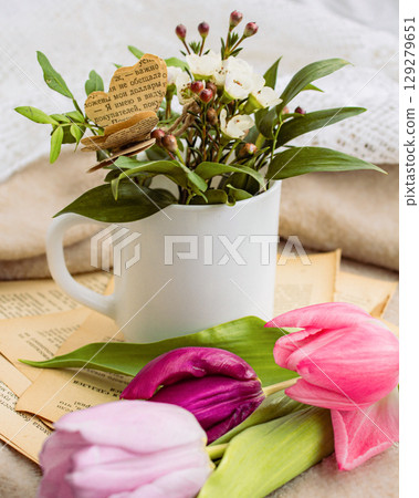 a beautiful arrangement of a bouquet of tulip flowers and a book 129279651