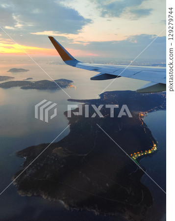beautiful thick clouds in the sky from the height of the flight of the plane with a view of the wing with engines 129279744