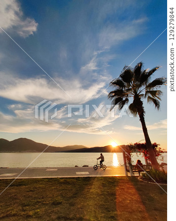 man riding a bicycle beautiful landscape of sunset on the sea beach man riding a bicycle beautiful landscape of sunset on the sea beach 129279844