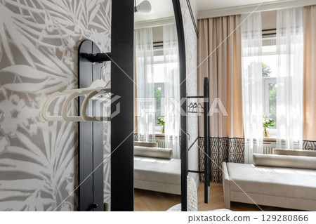 Reflection of Modern Cozy Room with Beige Curtains and Hangers 129280866