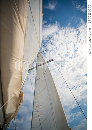 Full white sails blown by the wind against blue sky during sailing near Croatia. Symbol of movement, freedom and summer maritime journey. Full white sails blown by the wind against blue sky during sailing near Croatia. Symbol of movement, freedom and summer maritime journey. 129281001