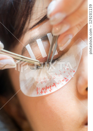 Young southeast asian woman in beauty salon for eyelashes extension procedure. relaxing session for natural beauty female eyes focusing on health wellness and makeup 129281139