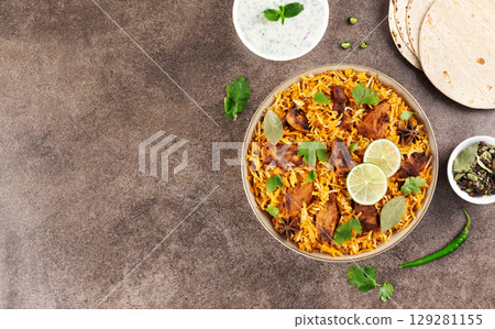 Spiced chicken masala biryani with flatbread and raita. Top view. Copy space. Indian food. Spiced chicken masala biryani with flatbread and raita. Top view. Copy space. Indian food. 129281155