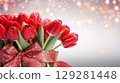 Huge bouquet of vibrant red tulips elegantly tied with a sparkling ribbon ready for gifting on any special occasion 129281448