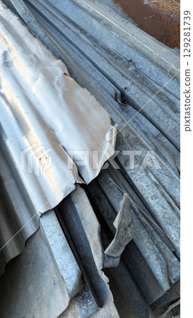 Piles of weathered metal sheets and strips, showcasing various textures and colors, stacked in a disorganized manner, reflecting industrial materials and construction elements Piles of weathered metal sheets and strips, showcasing various textures and colors, stacked in a disorganized manner, reflecting industrial materials and construction elements 129281739