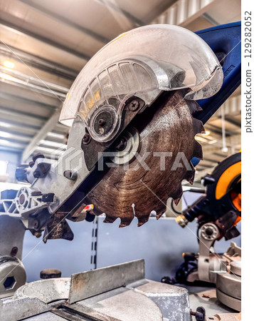 Powerful miter saw with sharp blade for wood or metalwork inside workshop. High quality photo 129282052