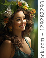 Woman adorned with spring flowers enjoys a sunny day in a lush green garden, radiating joy and tranquility 129282293