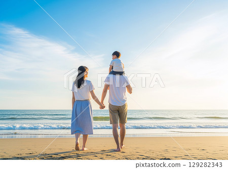 Parent and child walking along the beach 129282343