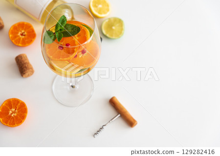 Sangria with citrus fruits and mint, corks and a corkscrew on a white background. Sangria with citrus fruits and mint, corks and a corkscrew on a white background. 129282416