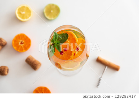 Sangria with citrus fruits and mint, corks and a corkscrew on a white background. 129282417