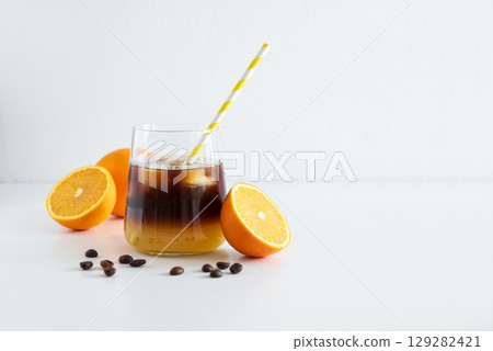 Layered Bumble Coffee with orange and espresso, served in a glass on white table 129282421