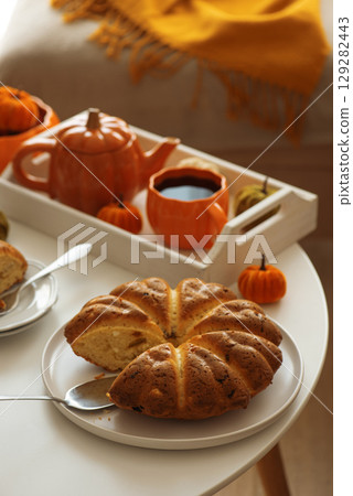 Autumnal living room decor with pumpkins, tea set and cake. Autumnal living room decor with pumpkins, tea set and cake. 129282443