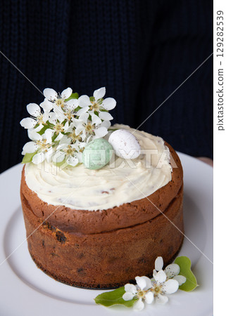 Enjoy a beautifully crafted homemade Easter cake topped with creamy frosting, colorful Easter eggs, and fresh spring blossoms that enhance the celebratory spirit of this delightful spring occasion. Enjoy a beautifully crafted homemade Easter cake topped with creamy frosting, colorful Easter eggs, and fresh spring blossoms that enhance the celebratory spirit of this delightful spring occasion. 129282539