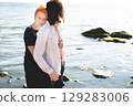 two lovers boy and girl are happy walking and hugging on the sandy beach near the sea. 129283006