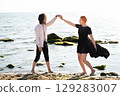 two lovers boy and girl are happy walking and hugging on the sandy beach near the sea. 129283007