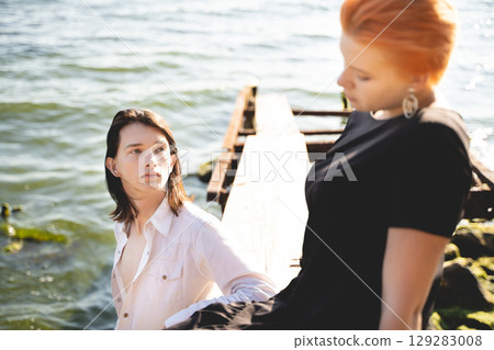 two lovers boy and girl are happy walking and hugging on the sandy beach near the sea. two lovers boy and girl are happy walking and hugging on the sandy beach near the sea. 129283008