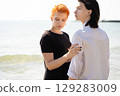 two lovers boy and girl are happy walking and hugging on the sandy beach near the sea. 129283009