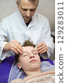 a cosmetologist doctor makes cosmetic procedures on the face of a young guy in a beauty salon 129283011