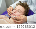 a cosmetologist doctor makes cosmetic procedures on the face of a young guy in a beauty salon 129283012