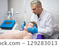 a cosmetologist doctor makes cosmetic procedures on the face of a young guy in a beauty salon 129283013