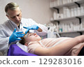a cosmetologist doctor makes cosmetic procedures on the face of a young guy in a beauty salon 129283016