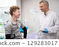 A man doctor talks to his boy patient and advises him on medicine 129283017