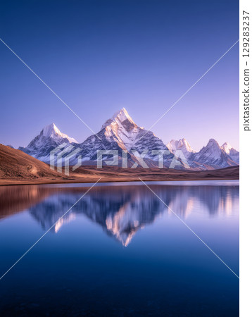 Snow-capped peaks reflected on the lake at sunrise 129283237