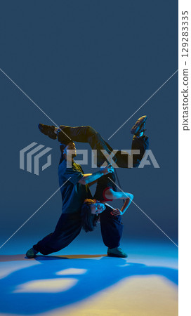 Dancers performing upside-down acrobatic hold with calm expression and full control Dancers performing upside-down acrobatic hold with calm expression and full control 129283335