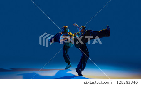 Hip hop duo holding intense dynamic lift with expressive eye contact and stability Hip hop duo holding intense dynamic lift with expressive eye contact and stability 129283340