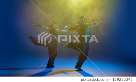 Hip-hop dancers performing mid-air with outstretched arms and bold attitude 129283345