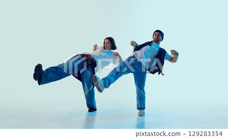 Male and female dancers kicking in rhythm with playful energy and expressive faces 129283354