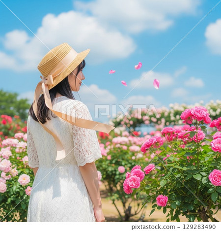 玫瑰田中一位戴著草帽的微笑女子的夏日肖像 129283490
