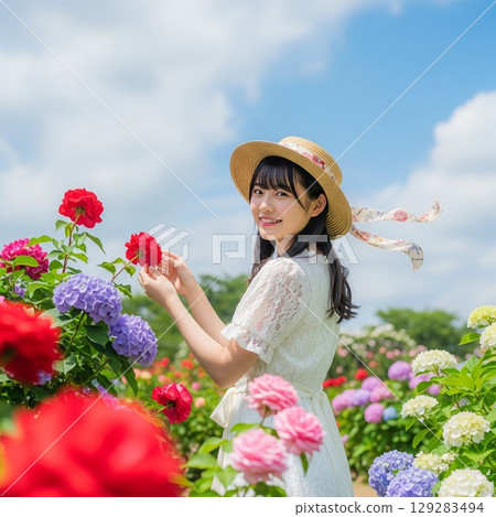 玫瑰田中一位戴著草帽的微笑女子的夏日肖像 玫瑰田中一位戴著草帽的微笑女子的夏日肖像 129283494