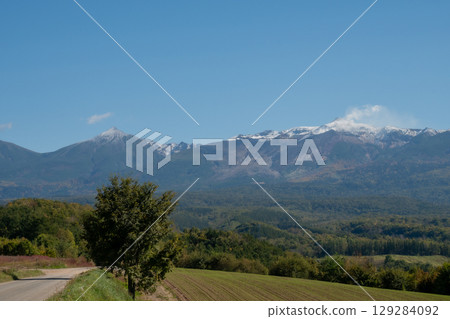 First snow on the volcanic summit and autumn forests - Mt. Tokachi 129284092