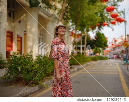 woman exploring streets of George Town, during Chinese New Year. 129284345