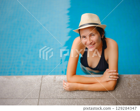 Young woman relaxing by the pool at a Kuala Lumpur hotel 129284347