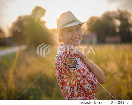 boho chic woman in a floral dress in European countryside 129284352
