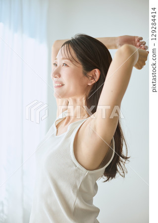 一位女士在窗邊伸展身體的肖像 - 健康的早晨生活方式 129284414
