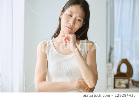 陷入沉思的女人,白色無袖,自然光,憂慮和焦慮 陷入沉思的女人,白色無袖,自然光,憂慮和焦慮 129284433