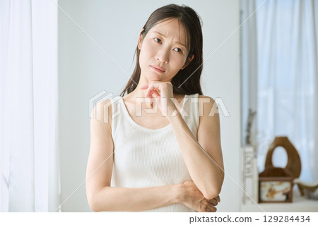 陷入沉思的女人,白色無袖,自然光,憂慮和焦慮 陷入沉思的女人,白色無袖,自然光,憂慮和焦慮 129284434