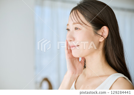 A smiling woman with her hands on her skin - ideal for beauty and skincare images A smiling woman with her hands on her skin - ideal for beauty and skincare images 129284441