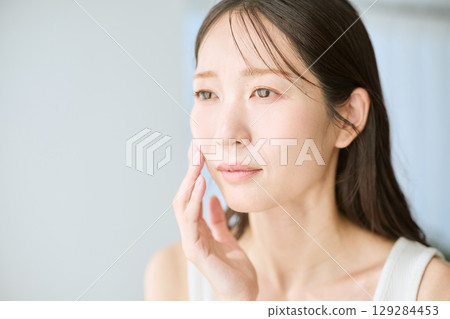 一位微笑、雙手放在皮膚上的女人 — — 非常適合美容和護膚的圖片 一位微笑、雙手放在皮膚上的女人 — — 非常適合美容和護膚的圖片 129284453