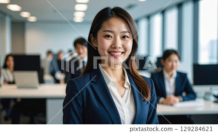 A career woman who successfully changed jobs. A young Japanese female business person smiling confidently in the office. 129284621