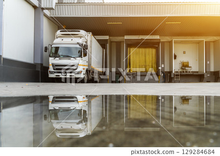 Trailer Container Truck Parked in front of the ramps for load/unload goods at the distribution warehouse center in the factory. Shipping Shipment Cargo concept. 129284684