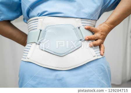 Asian senior pain back wearing elastic support belt with walker. Asian senior pain back wearing elastic support belt with walker. 129284715