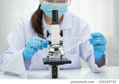 Scientist medical professional use microscope for research in science laboratory. 129284716