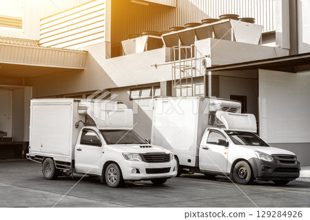 Refrigerated pickup trucks are parked in front of the factory, transporting frozen goods. Refrigerated pickup trucks are parked in front of the factory, transporting frozen goods. 129284926