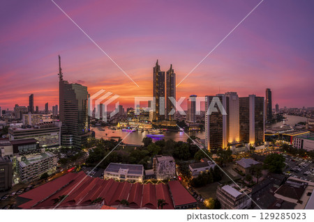 Modern buildings in the city with water reflection, firework, light show at twilight time. 129285023