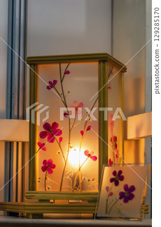 Lantern decorated with natural dried flowers and illuminated from within creates warm and inviting glow. Soft petals and intricate patterns create cozy and tranquil atmosphere. Handmade Lantern decorated with natural dried flowers and illuminated from within creates warm and inviting glow. Soft petals and intricate patterns create cozy and tranquil atmosphere. Handmade 129285170